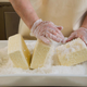 Person handling cheese with gloves on